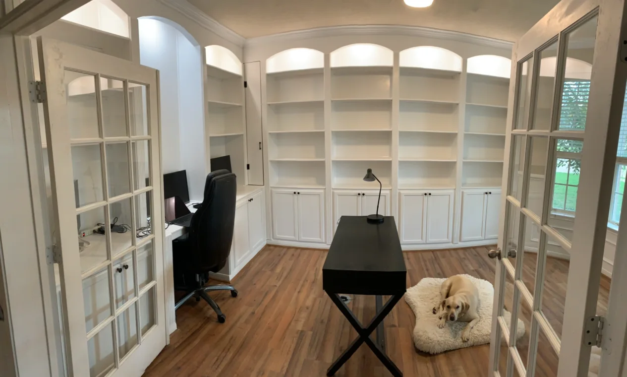 Finished white built-in office library with shelves and French doors